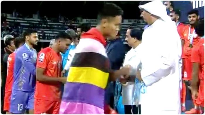 ভারতীয় দলের মণিপুরী মিডফিল্ডার জিকসন সিং, তার রাজ্যে চলা হিংসার ঘটনার ‘প্রতীকী’ প্রতিবাদে মেইতেই (Meitei) পতাকা গায়ে জড়িয়ে পদক নিতে হাজির হন।