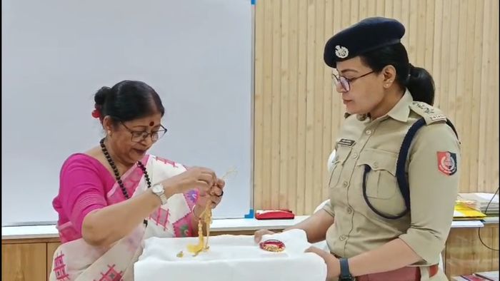 উদ্ধার করা গয়না তুলে দিচ্ছেন পুলিশ সুপার।-ফাইল ছবি