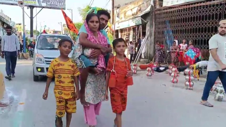 पति को पीठ पर बिठा ले जाती पत्नी पति को पीठ पर बिठा ले जाती पत्नी