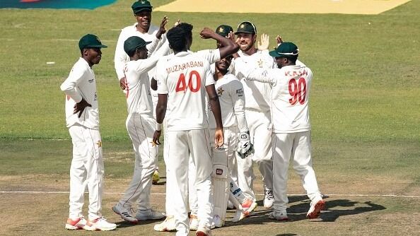 Zimbabwe's captain Brendan Taylor (2nd R) celebrates with teammates after taking a wicket during the first day of the Test cricket match between Zimbabwe and Bangladesh at the Harare Sports Club in Harare on July 7, 2021.