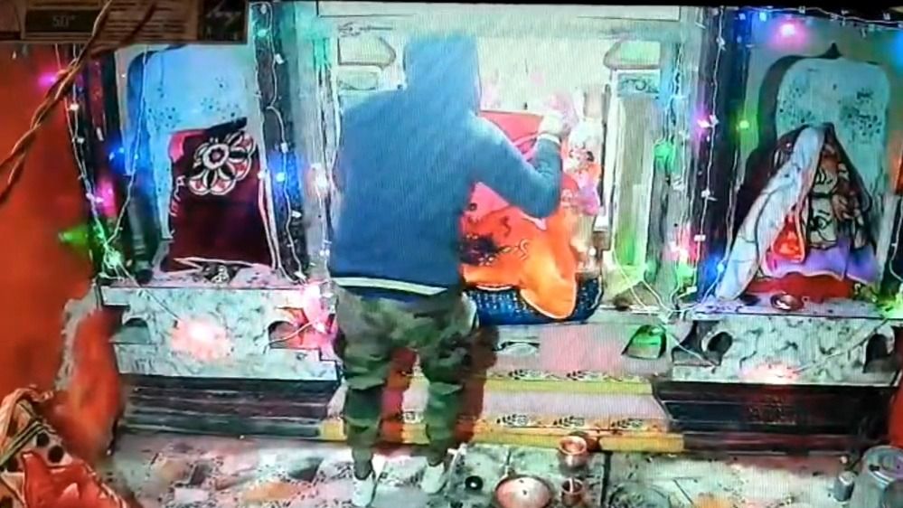 मंदिर से चोरी करता युवक