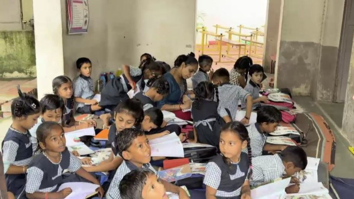 जमीन पर बैठ पढ़ते बच्चे