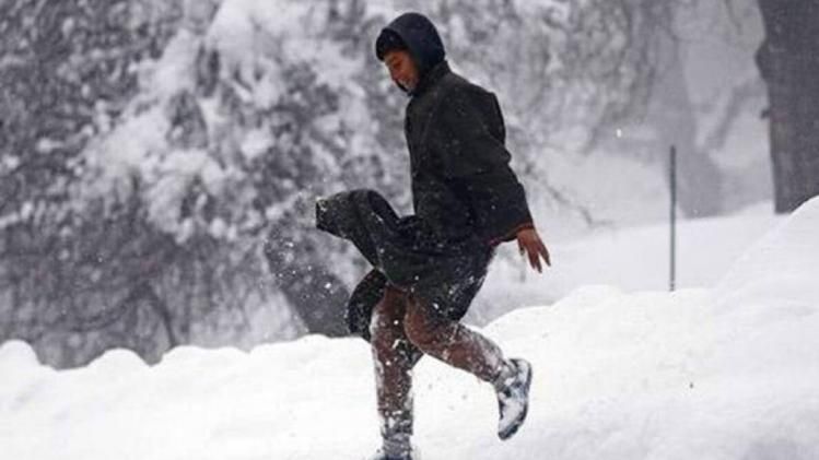 tourists swing amidst snowfall