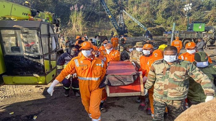 मदत आणि बचाव पथकाचे सदस्य मृतदेह घेऊन जात आहेत