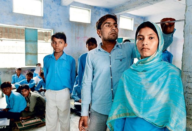 मेवात जिले के राजकीय उच्च विद्यालय में स्वास्थ्य जांच करता शिक्षक