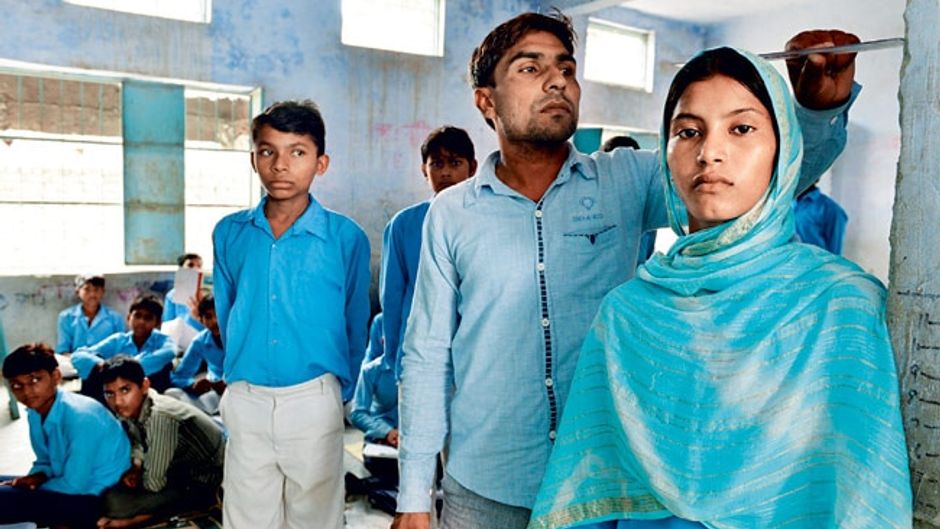 मेवात जिले के राजकीय उच्च विद्यालय में स्वास्थ्य जांच करता शिक्षक