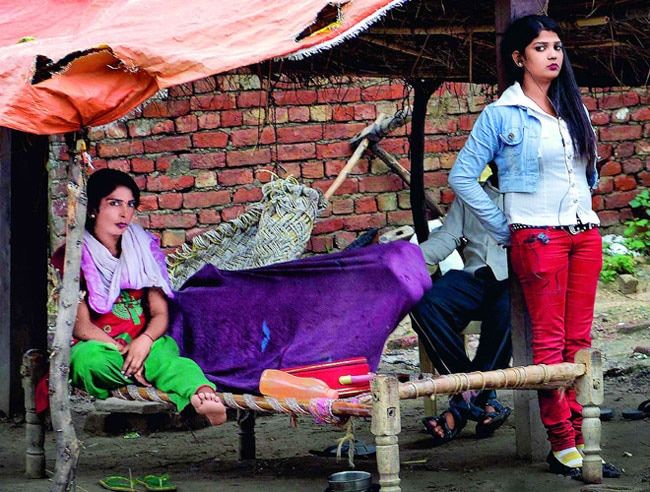 कैमरा देखते ही दो बहनें चौकन्‍नी हो उठीं जबकि तीसरी चादर में छुप गई