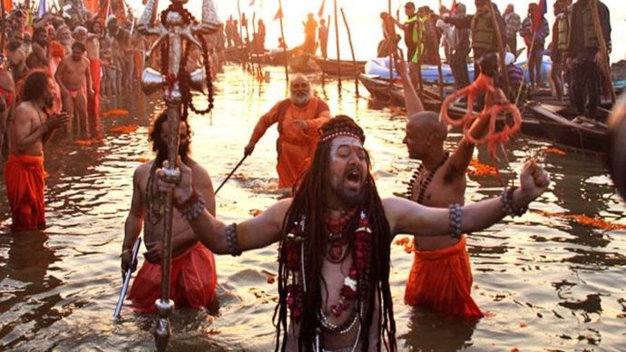 संगम में डुबकी लगाते साधु