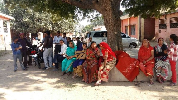 किसान की मौत के बाद घर के बाहर बैठीं गमजदा महिलाएं