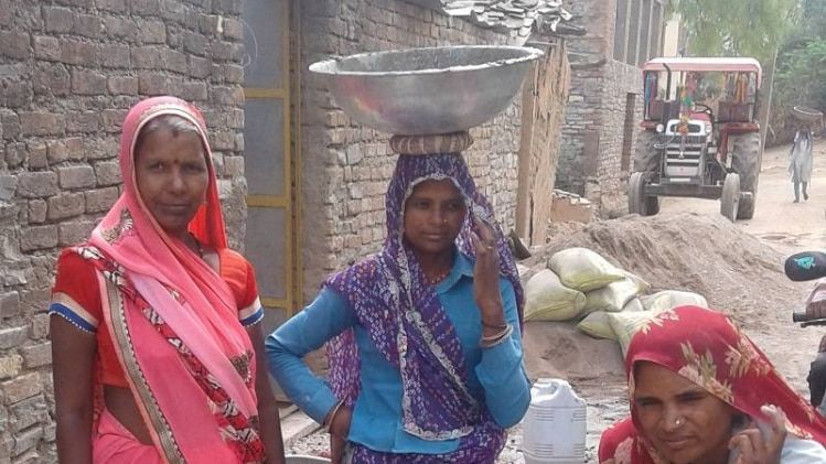 शौचालय निर्माण के समय गुलाबी साड़ी में प्रेम बाई