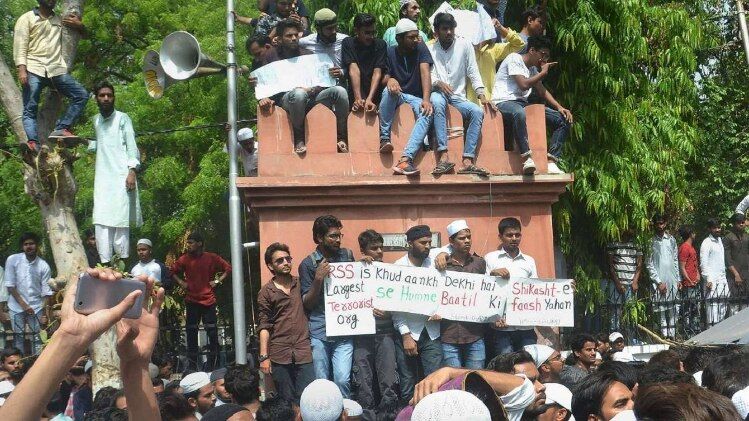  नाराजगी हाल के बवाल के बाद दोषियों पर कार्रवाई की मांग के लिए आंदोलन करते एएमयू के विद्यार्थी; और 