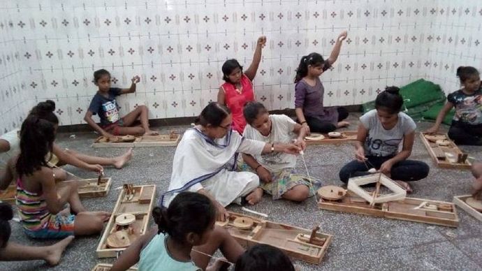 चरखा चलाते बच्चे