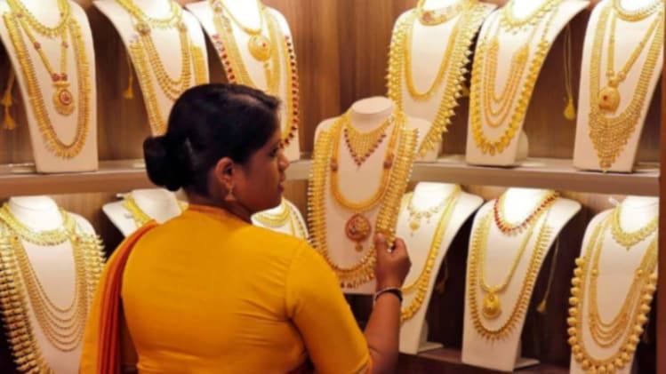 एक दुकान में ग्राहक को आभूषण दिखाती सेल्सवुमेन (फाइल फोटोः रॉयटर्स)