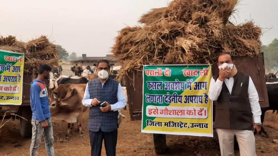 उन्नाव में ट्रैक्टर ट्राली में पराली लेकर आए किसानों के साथ अधिकारी