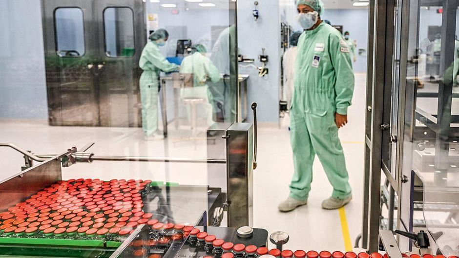 मेडिसिन मेन ऐस्ट्राजेनेका और ऑक्सफोर्ड यूनिवर्सिटी की वैक्सीन उम्मीदवार एजेडडी1222 के फिलिंग और पैकेजिंग के दौरान कैप लगाए जाने का निरीक्षण करता एक लैब टेक्निशियन