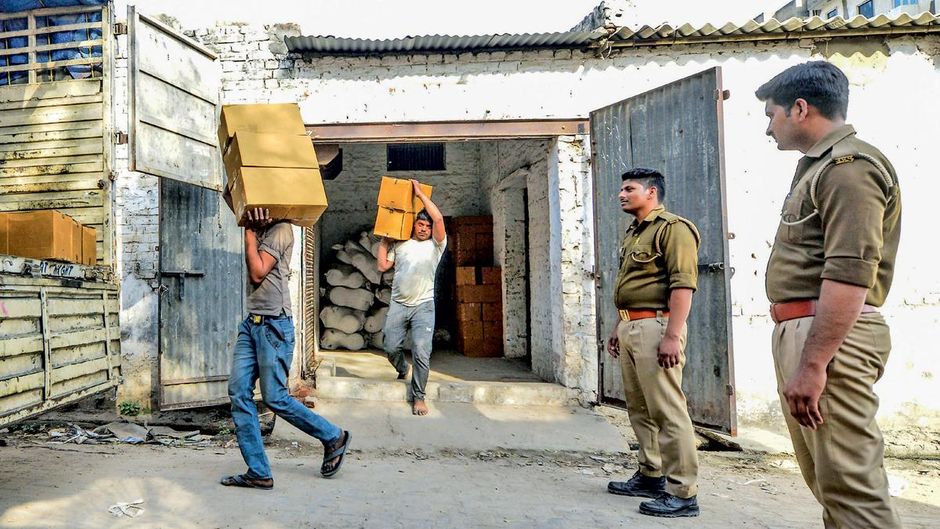 काला धंधा मथुरा के गोविंदनगर थाना क्षेत्र में एक ट्रांसपोर्टर के गोदाम में अवैध रूप से रखी फेन्सेड्रिल कफ सिरप की 45,000 बोतलें बरामद करती पुलिस