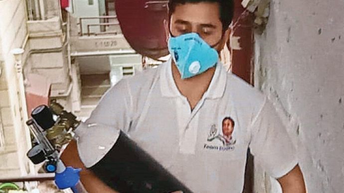 ताकि सांस न रुके युवा कांग्रेस का एक कार्यकर्ता दिल्ली के एक घर में ऑक्सीजन पहुंचाते हुए
