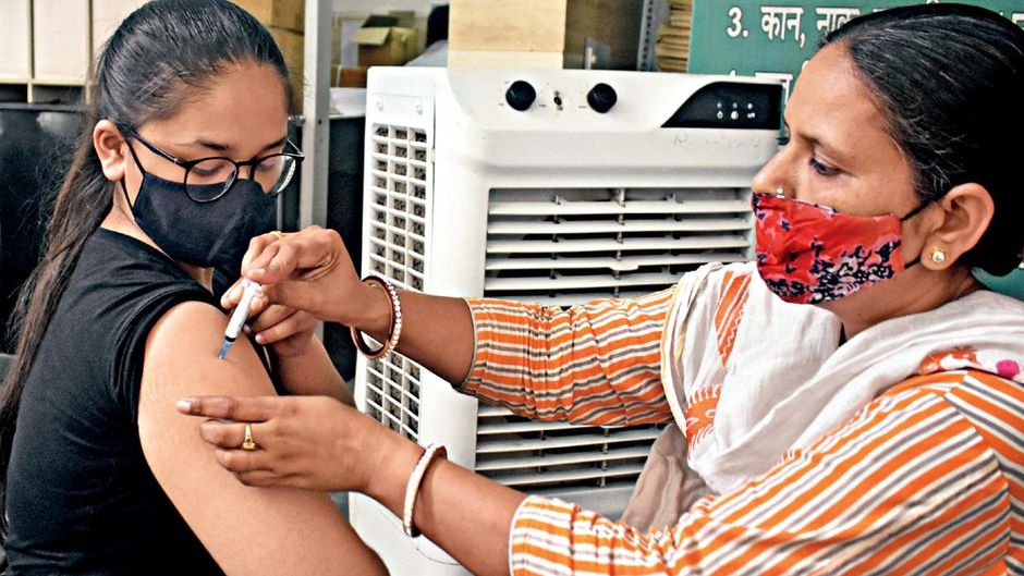 रगों में रक्षा कवच : गुरुग्राम में कोविड टीका लगाती एक स्वास्थ्यकर्मी