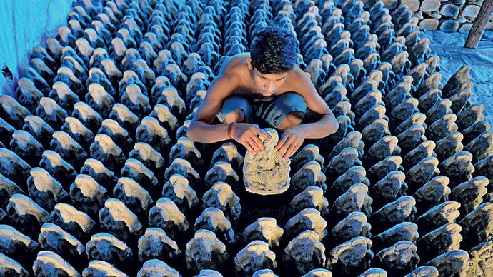 हैदराबाद के पास मिट्टी से गणेश की मूर्ति बनाता एक कारीगर