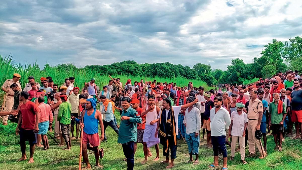 बलुआ गांव में बाघ की मौजूदगी वाले खेत के पास जमा भीड़ 