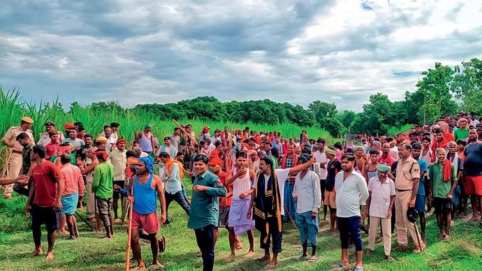 बलुआ गांव में बाघ की मौजूदगी वाले खेत के पास जमा भीड़