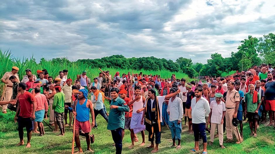 बलुआ गांव में बाघ की मौजूदगी वाले खेत के पास जमा भीड़