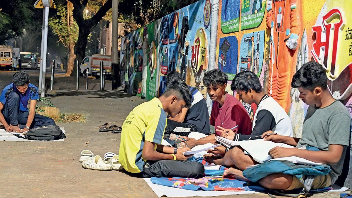 पाठशाला: मुंबई के व्यस्त वर्ली नाका सड़क के किनारे शाम को पढ़ाई करते बच्चे