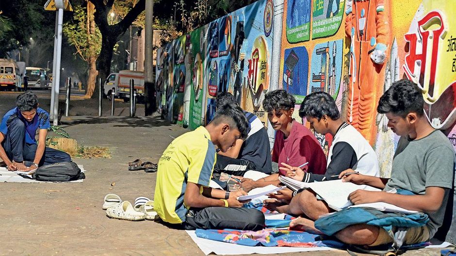 पाठशाला: मुंबई के व्यस्त वर्ली नाका सड़क के किनारे शाम को पढ़ाई करते बच्चे