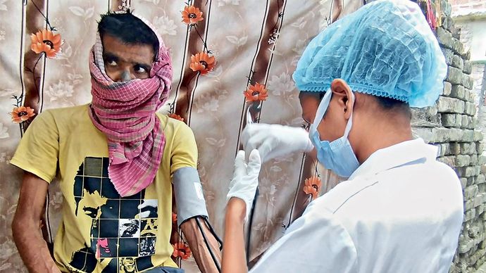 आखिरी स्टेज के कैंसर से जूझ रहे मुजफ्फरपुर के मोहम्मद इकरामुल के घर पर उनकी जांच करती एक नर्स