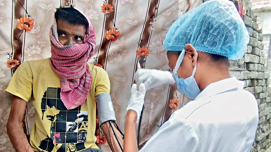 आखिरी स्टेज के कैंसर से जूझ रहे मुजफ्फरपुर के मोहम्मद इकरामुल के घर पर उनकी जांच करती एक नर्स