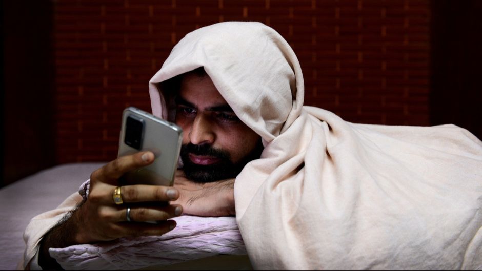 फोन चलाता एक युवक (प्रतीकात्मक तस्वीर)