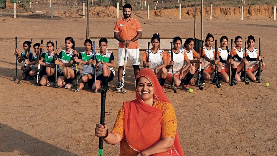 गांव के मैदान में हॉकी खिलाड़ियों के साथ सरपंच नीरू यादव