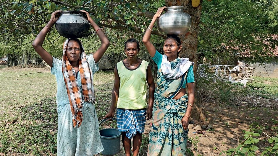 झारखंड में सिमडेगा जिले के अपने गांव में दूर से पानी लेकर आते सलीमा टेटे के परिजन