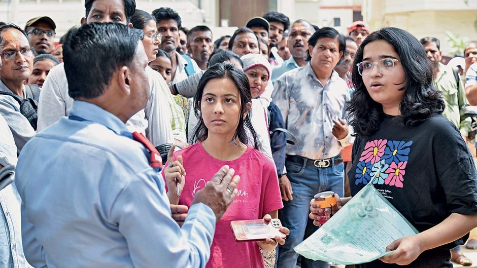 दिल्ली विश्वविद्यालय के एक कॉलेज के बाहर जमा परीक्षार्थी और उनके परिजन