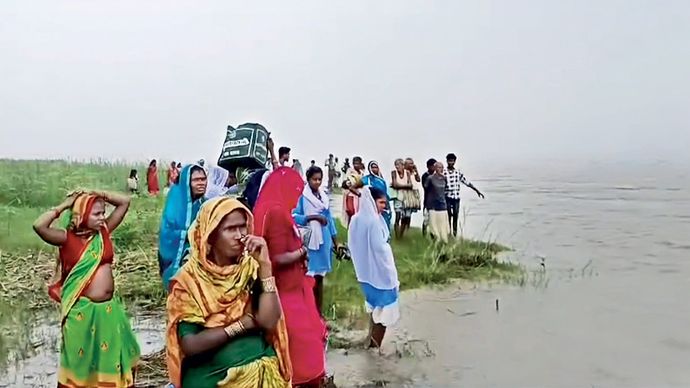 कोसी के तटबंध के बीच बसे एक गांव में फंसे बाढ़ पीड़ित लोग