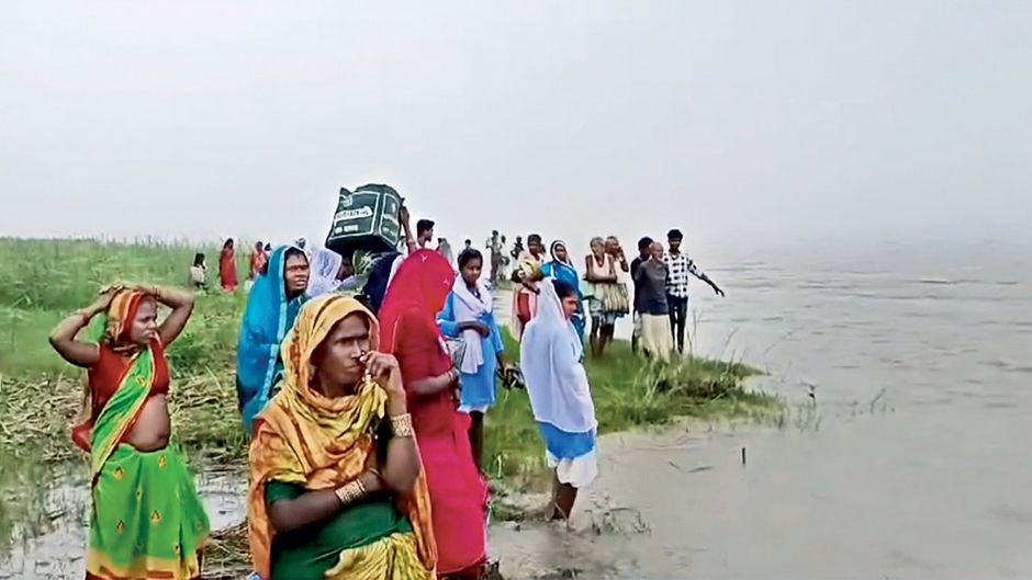 कोसी के तटबंध के बीच बसे एक गांव में फंसे बाढ़ पीड़ित लोग