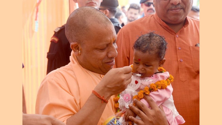 गोरखपुर के वनटांगिया गांव में बच्चे का अन्नप्राशन करते मुख्यमंत्री योगी आदित्यनाथ