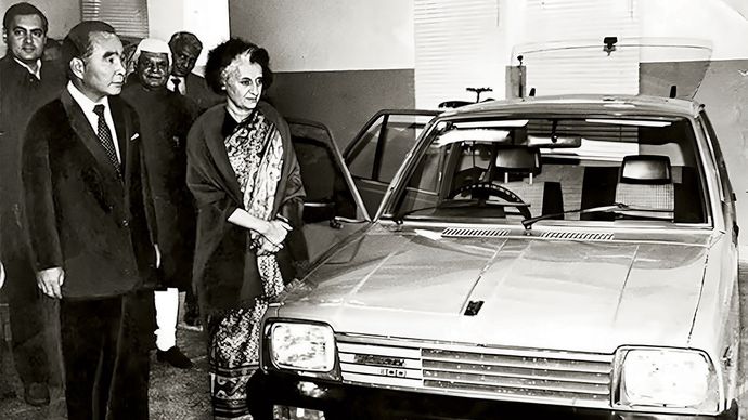 प्रधानमंत्री इंदिरा गांधी, राजीव गांधी (सबसे बाएं) और सुजुकी के चेयरपर्सन ओ. सुजुकी दिसंबर 1983 में नई दिल्ली में मारुति 800 कार के साथ