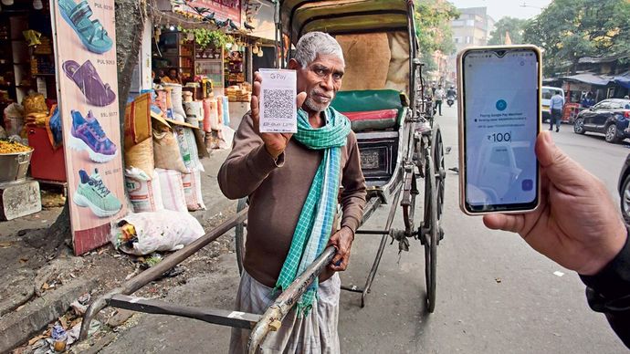 कोलकाता का एक रिक्शाचालक यूपीआई से किराया लेते हुए