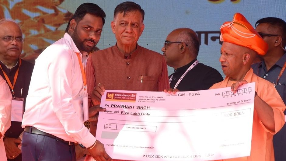 मुख्यमंत्री योगी आदित्यनाथ युवा उद्यमी योजना के एक लाभार्थी को चेक देते हुए (फाइल फोटो)