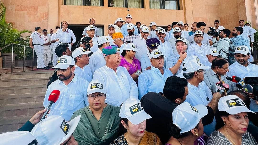 राजस्थान विधानसभा के बाहर विपक्षी विधायक 'जग्गा जासूस' लिखी कैप लगाकर प्रदर्शन करते हुए