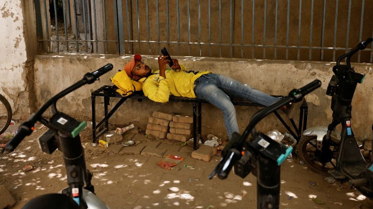 डिलीवरी की भागदौड़ के बीच सुस्ताता एक गिग वर्कर