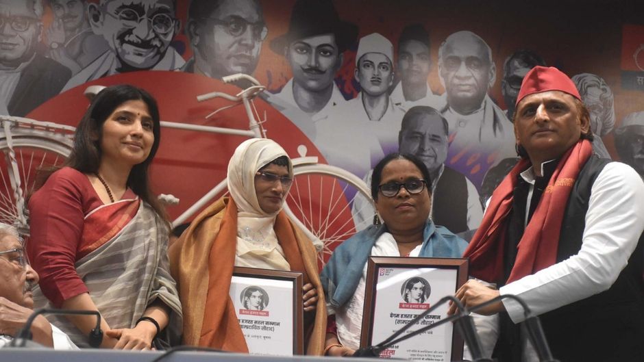 सपा कार्यलय में महिलाओं को सम्मानित करते अखिलेश और डिंपल यादव