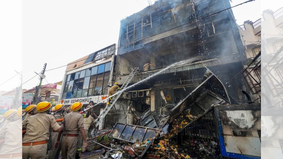 Fire personnel conduct a dousing operation after fire broke out at a commercial building in Aliganj, Lucknow