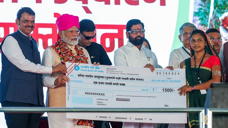 अक्तूबर 2024 में लाडकी बहिण योजना के तहत लाभार्थियों को चेक वितरित करते पीएम मोदी और सीएम फडणवीस