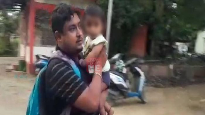 Accused carrying his child to the police station to surrender himself before the authorities