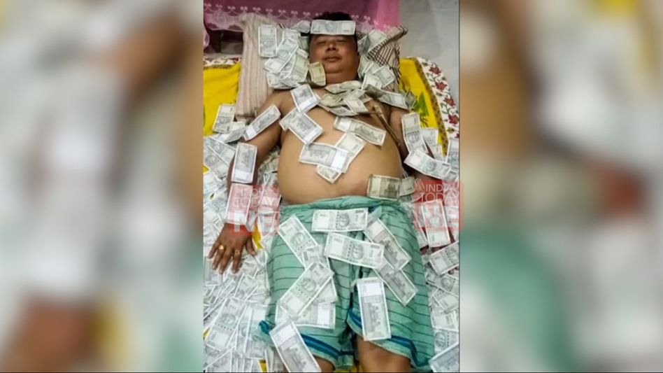 Assam: UPPL member found sleeping on stacks of Rs 500 notes, pic goes viral Assam: UPPL member found sleeping on stacks of Rs 500 notes, pic goes viral