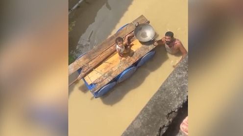 Assam flood crisis deepens, father ferries child in makeshift drum boat through neck-deep waters in Sivasagar