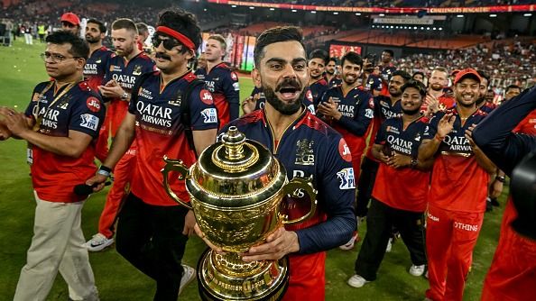  Virat Kohli (C), along with his teammates, takes a victory lap around the field as he celebrates with the trophy after winning the Indian Premier League (IPL) Twenty20 final cricket match against Punjab Kings at the Narendra Modi Stadium 