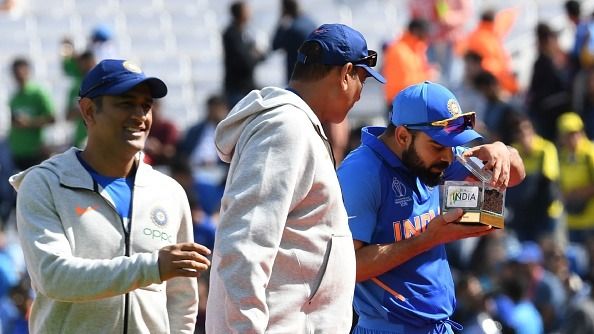 Indian cricket captain Virat Kohli (R) is watched by India's Mahendra Singh Dhoni (L) and India's head coach Ravi Shastri (C)